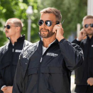 a group of security guards talking on the wireless wearing black sunglasses at security guard services in Houston, TX.