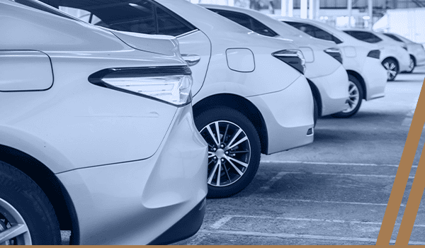 a row of white cars parked in a parking lot.