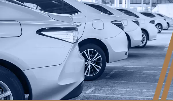 a row of white cars parked in a parking lot.