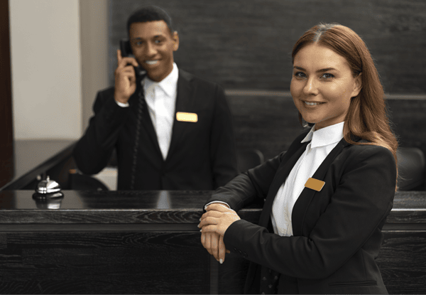 Well-groomed concierge team assisting guests at the front desk